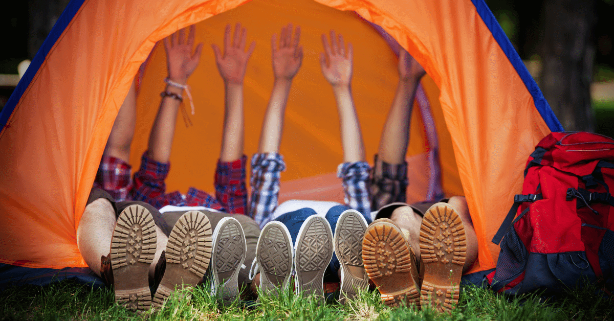 4 people with their legs sticking out of a tent