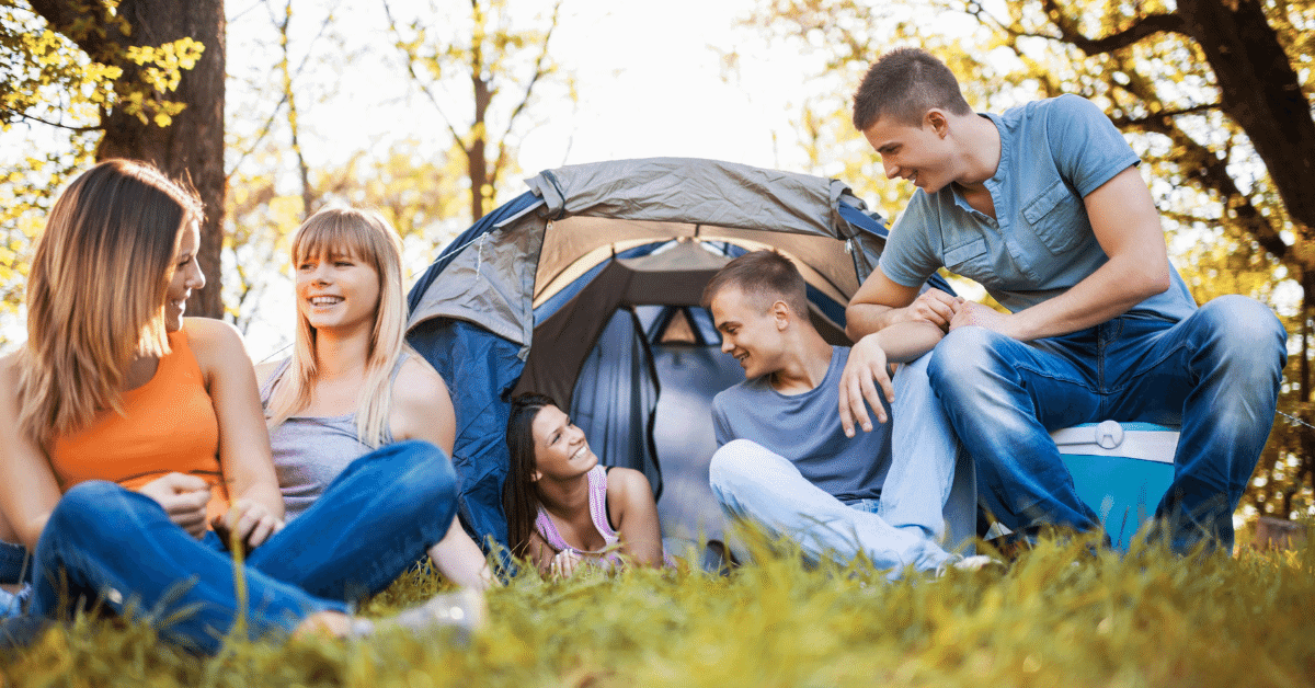 5 people chilling in front of a tent