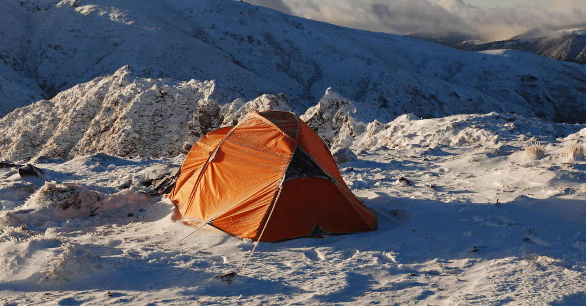 an orange tent in the snow