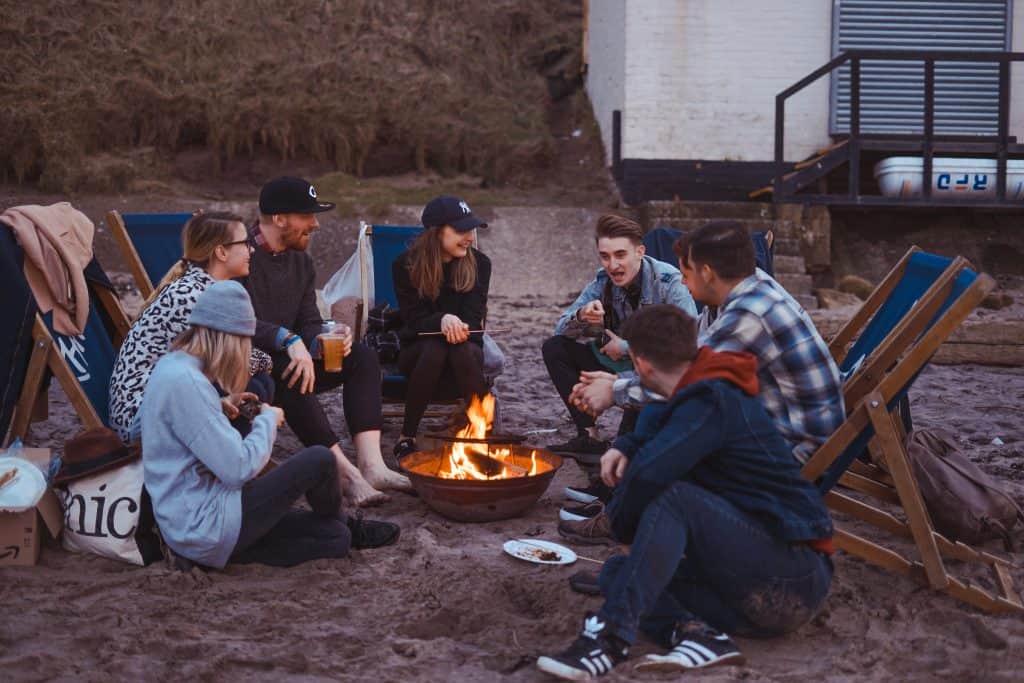 Group of friends eating by the campfire