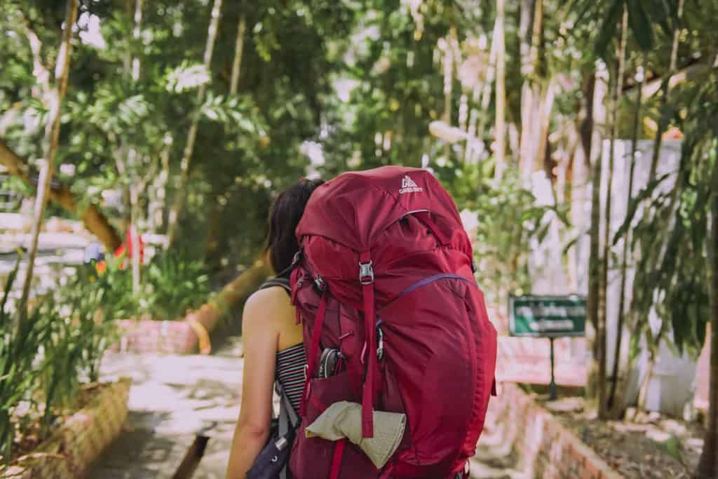 girl in trees with stuffed backpack