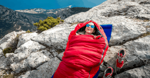 woman sleeping on a rock in a sleeping bag