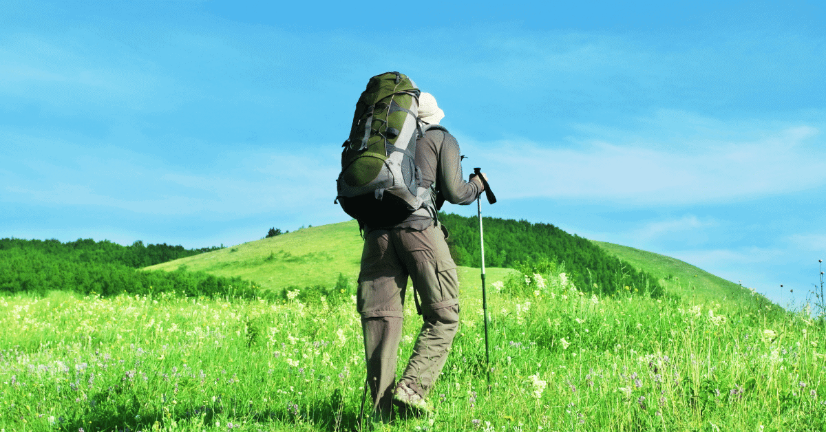 man hiking through field