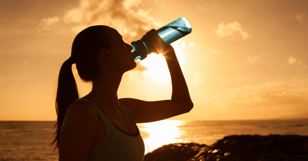 a woman drinking water from a bottle