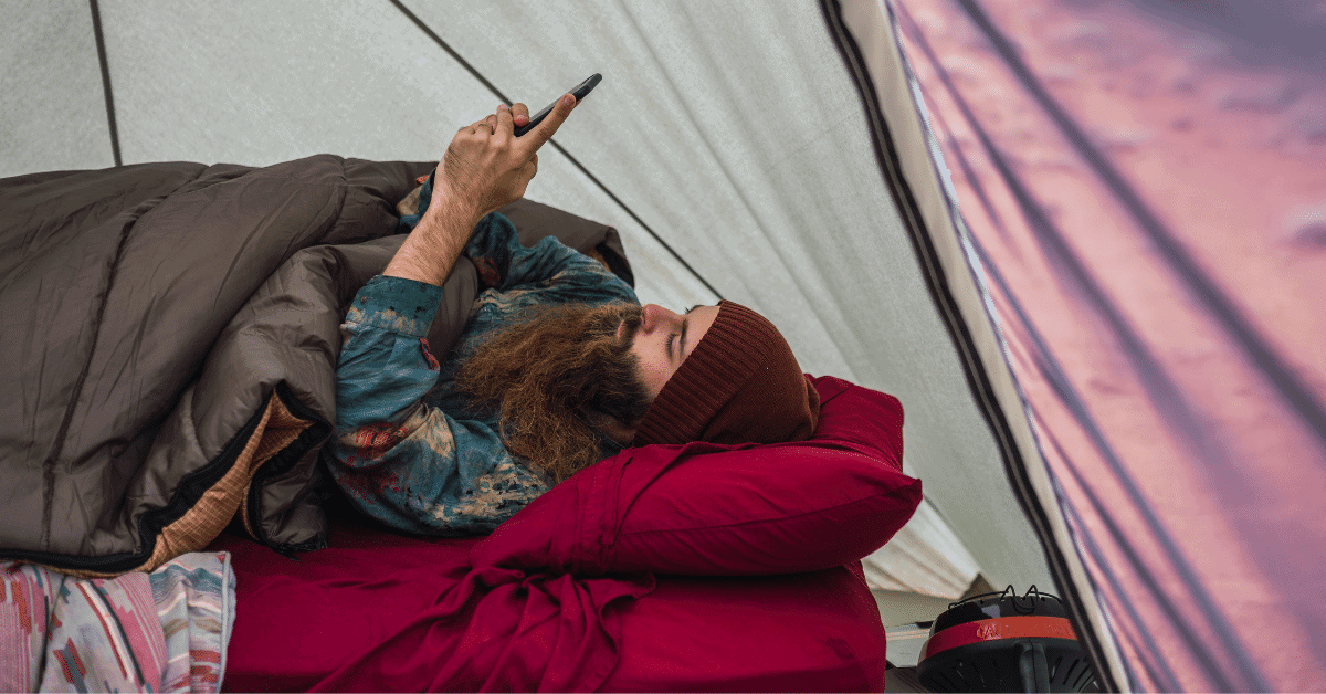 a man laying on an air mattress in a tent