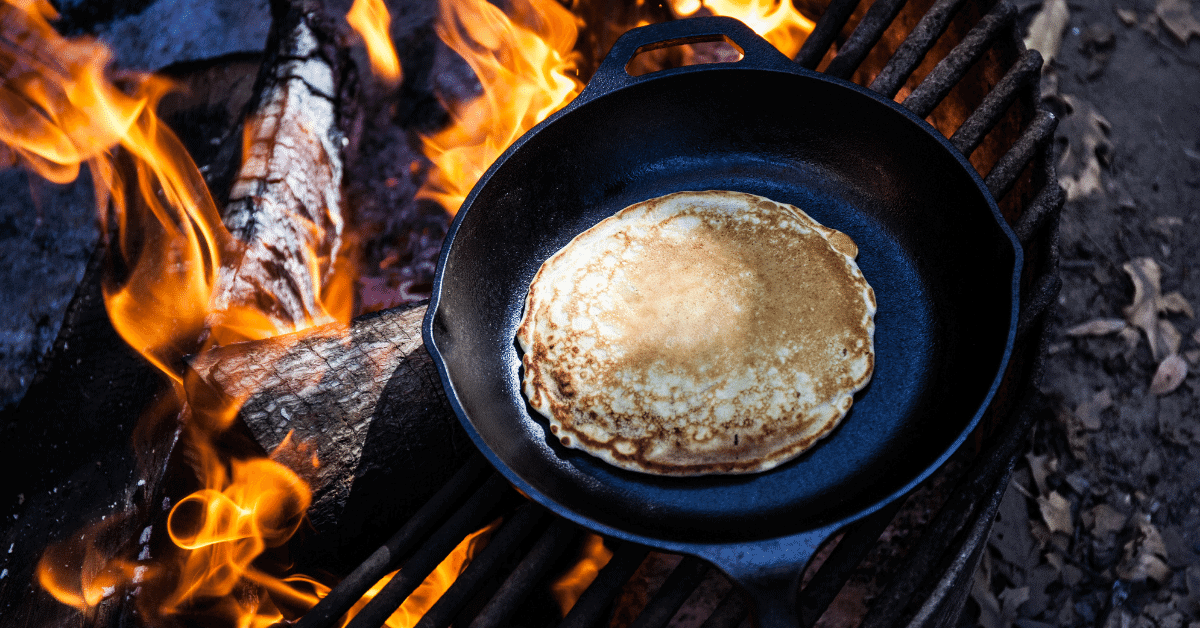 a pancake cooking on a campfire