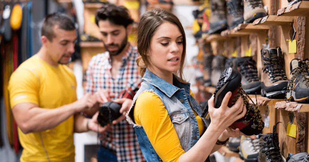 a woman looking at hiking boots in a store