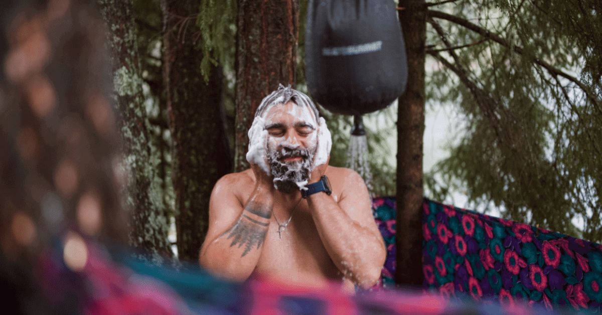 a man taking a shower outdoors using a solar water heating bag