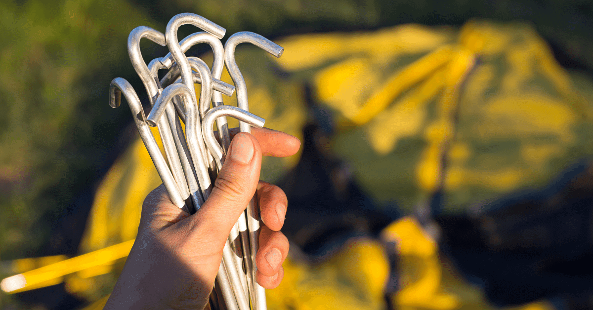 a person holding a set of shepherds hook tent stakes