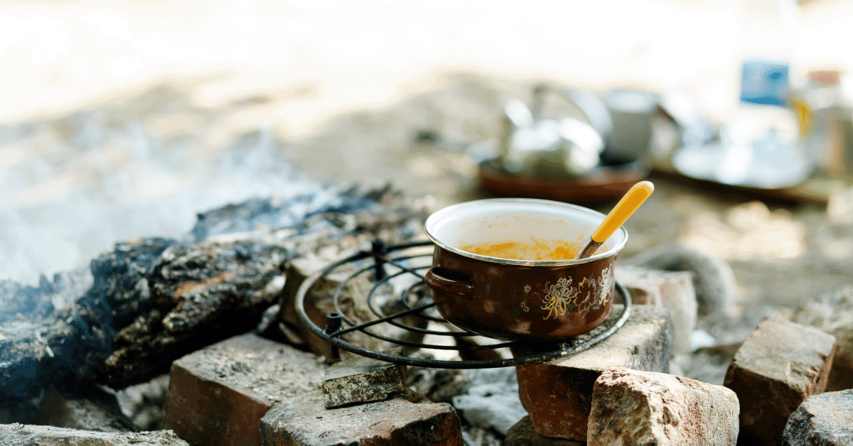 a pot of food cooking on the campfire
