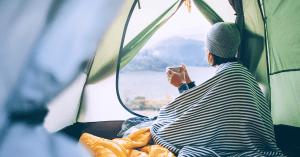 a woman drinking coffee in a tent
