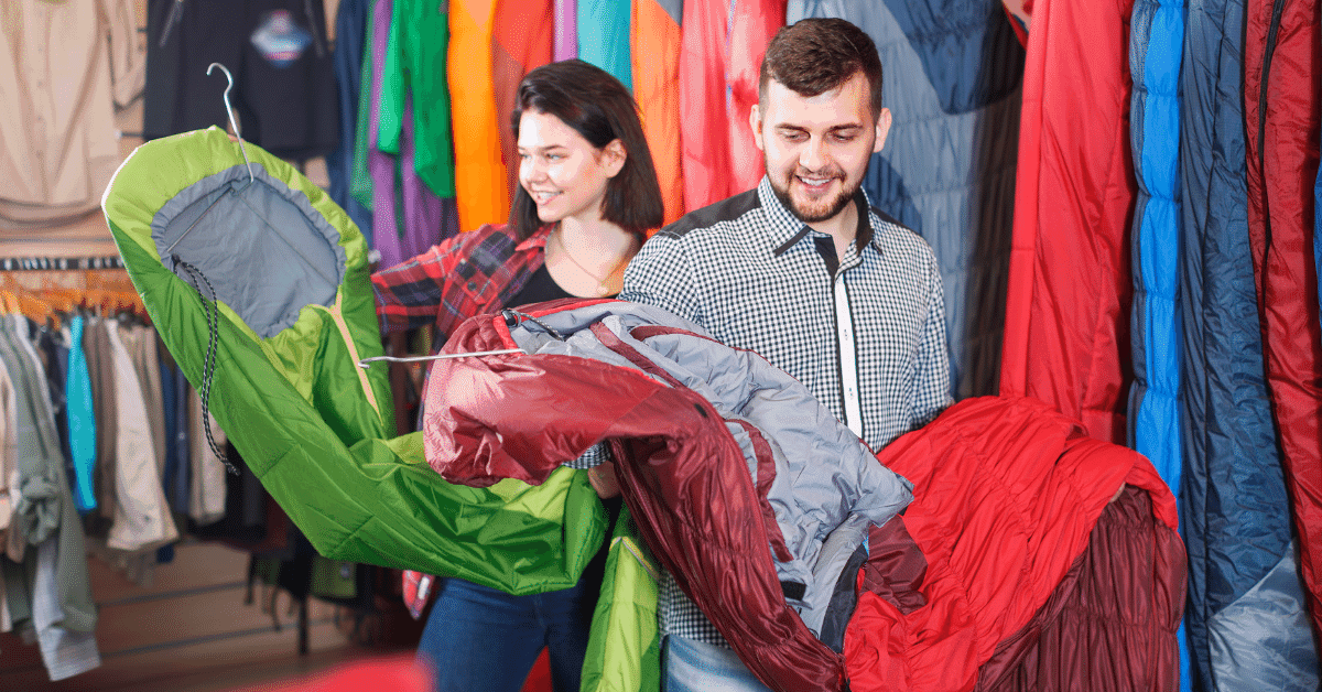 young couple shopping for sleeping bags