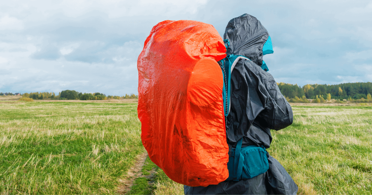 hiker wearing rain gear and a backpack with a rain cover