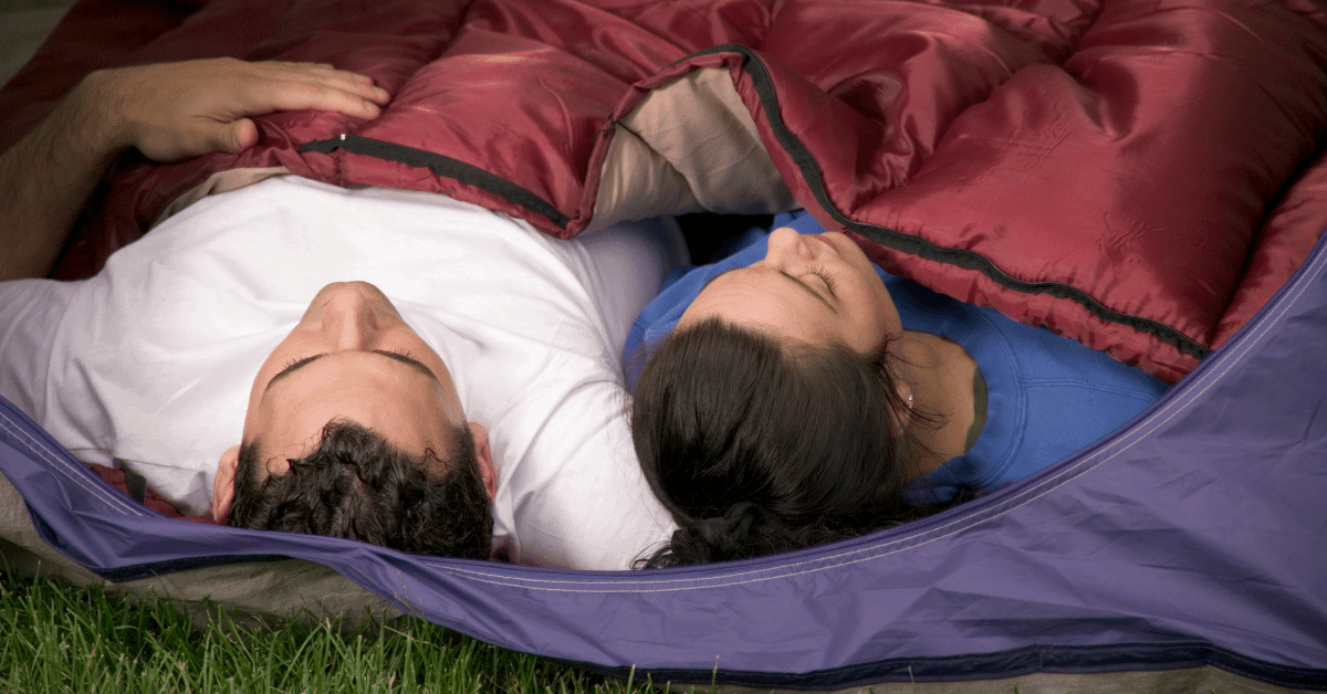 man and woman sleeping in a double sleeping bag