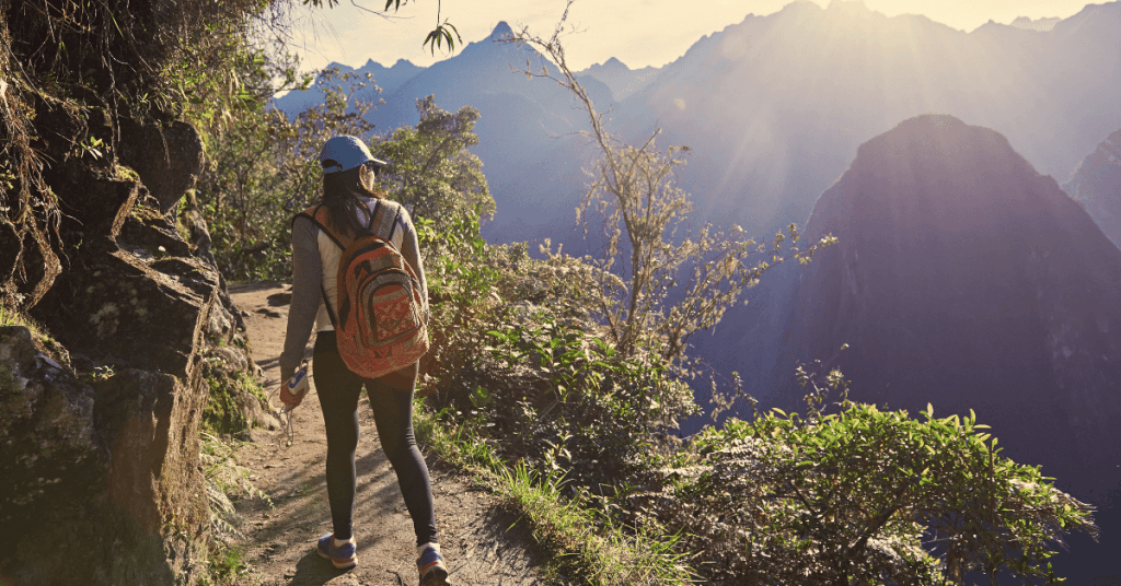 woman day hiking along a trail on a mountain