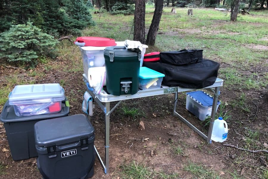 a camping table stacked with gear