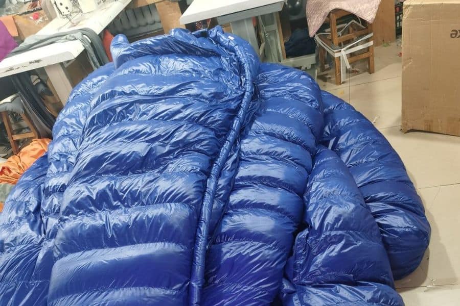 Down sleeping bags piled in a factory