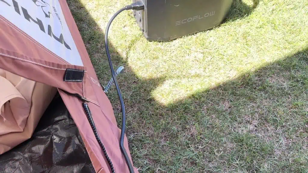 Cable de alimentación BougeRV 3500BTU encaminado desde la tienda hasta la central eléctrica EcoFlow en el exterior