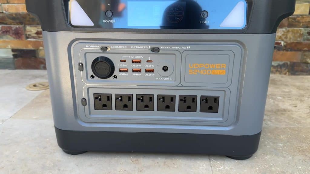 Close-up of UDPower S2400 output panel showing six AC outlets, PD 100W USB-C, USB-A ports, 12V DC, and solar input
